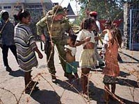 Fotografa Un grupo de nios juega con un soldado en la frontera de Ruanda